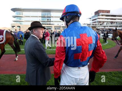 Jonjo O'Neill spricht mit seinem Jockey James King vor der Joel Dommett hier am 6. April Amateur Riders' Handicap Chase Während des Tages eines der Showcase auf der Cheltenham Rennbahn Stockfoto