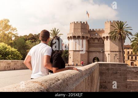 Paar beobachten die Serrano Türme im Hintergrund, auf der Steinbrücke. Junges Paar Sightseeing in Valencia. Stockfoto