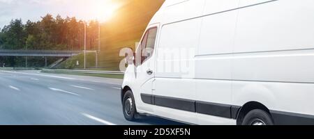 Weiße moderne Lieferung kleine Sendung Fracht Kurier van schnell auf Autobahn Straße zu Stadt städtischen Vorort bewegen. Geschäft Vertrieb und Logistik Express Stockfoto