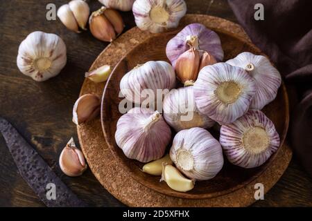 Knoblauch. Knoblauchzehen und Glühbirne auf rustikalem Holztisch. Stockfoto