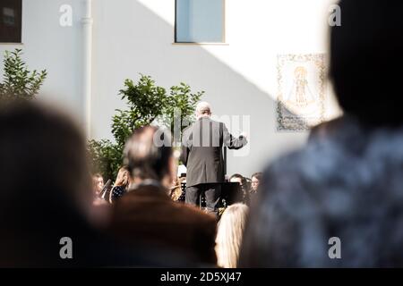 Die Fotografie konzentrierte sich auf den Dirigenten des klassischen Orchesters aus der Sicht der Öffentlichkeit. Menschen in der Öffentlichkeit nicht im Fokus. Stockfoto