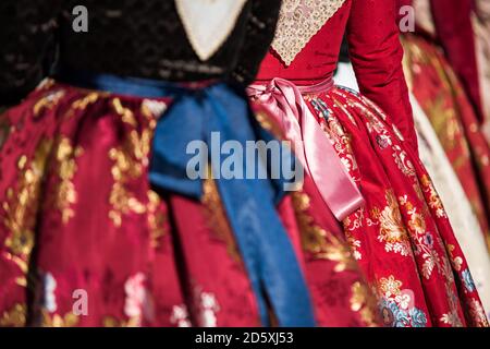 Detail des typischen Kleides der fallas von Valencia. Nahaufnahme Fotografie auf einem der Röcke mit floralen Motiven konzentriert. Rote Kleider. Stockfoto