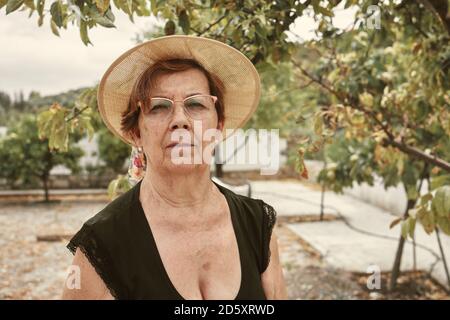 Nahaufnahme einer alten Dame in ihrem kleinen Stadtgarten. Obstgarten-Konzept Stockfoto