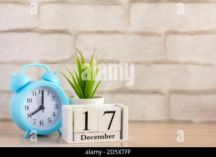 Dezember 17 auf dem Holzkalender neben dem Wecker, der erste Tag des ersten Wintermonats. Stockfoto