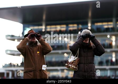 Racegoers schauen durch ein Fernglas vor der Prinzessin Royal Stand während des ersten Tages des Internationalen Treffens in Cheltenham Rennbahn Stockfoto