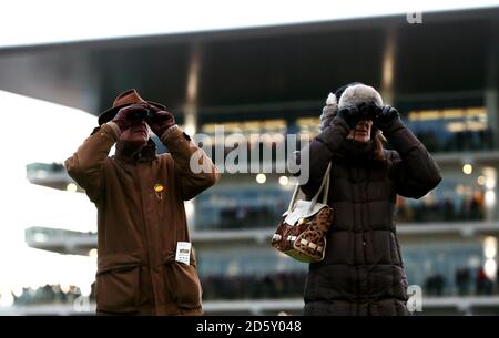 Racegoers schauen durch ein Fernglas vor der Prinzessin Royal Stand während des ersten Tages des Internationalen Treffens in Cheltenham Rennbahn Stockfoto