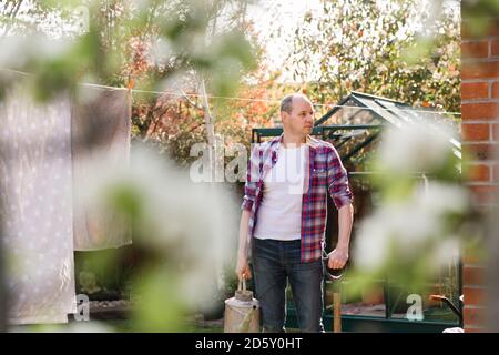 Mann mit Gießkanne im Garten Stockfoto