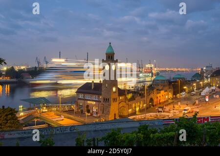 Deutschland, Hamburg, Uhrturm bei Landungsbrücken und ankommendes Kreuzfahrtschiff am Morgen Stockfoto