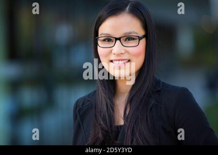 Porträt der lächelnde junge Geschäftsfrau mit Brille Stockfoto