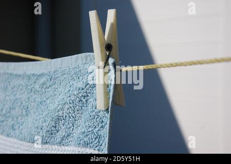 Ein Badetuch auf dem Draht durch eine Wäscheklammer Trocknen in der Sonne auf der heimischen Terrasse gehängt. Leben zu Hause. Stockfoto