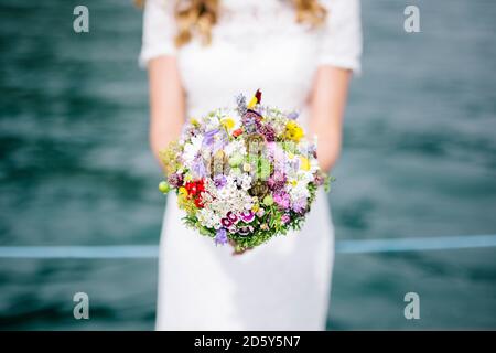 Braut hält ihren Blumenstrauß Stockfoto