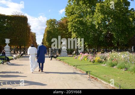 Paris, Frankreich - 26. September 2020: Brautpaar zu Fuß bt der Tuilerien-Garten, zwischen dem Louvre und der Concorde Plaza im ersten Viertel Stockfoto