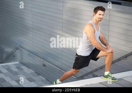 Sportler tun stretching Übungen auf einer Treppe Stockfoto