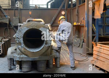 Arbeiter mit Kreissäge in einer Gießerei Stockfoto