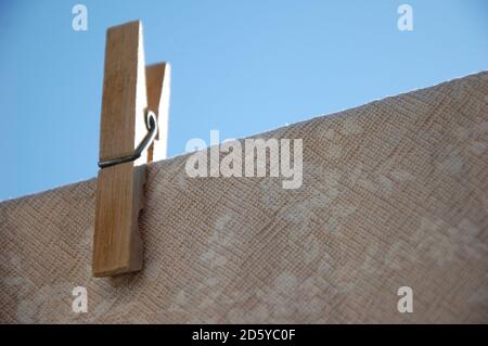 Eine Wäscheklammer hängt ein Tischtuch auf einem Draht und blauen Himmel über. Trocknung in der Sonne Stockfoto