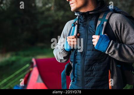 Mann, der in Estland zeltet und das Lager mit Rucksack für eine Wanderung verlässt Stockfoto