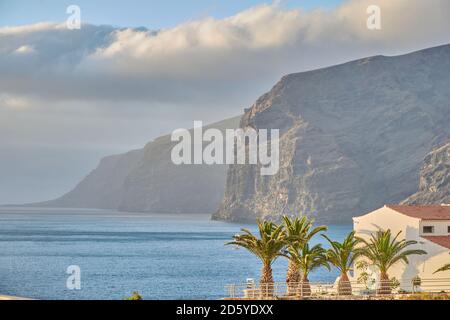 Panoramaküste auf Teneriffa, Spanien. Riesige Klippen an der Küste Teneriffas mit Palmen im Vordergrund. Stockfoto