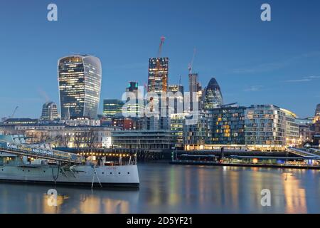 Großbritannien, London, Skyline mit Bürotürmen und HMS Belfast Museumsschiff in der Abenddämmerung Stockfoto