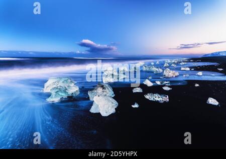 Island, Blick auf Glazial-See Jökulsárlón Gletschereis am Strand in der Abenddämmerung Stockfoto