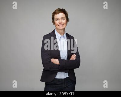Porträt von lächelnden Reife Frau mit verschränkten Armen Stockfoto