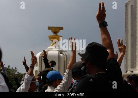 Während der Demonstration grüßen regierungsfeindliche Demonstranten mit drei Fingern: Tausende von Demonstranten marschierten in Richtung Regierungshaus in Bangkok und forderten den Rücktritt von Thailands Premierminister Prayuth Chan-ocha und Reformen in der Monarchie. Stockfoto
