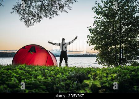 Mann Camping in Estland, Stretching am See Stockfoto