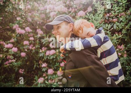 Vater gibt seinem Sohn beim Wandern ein Schweinchen zurück Stockfoto