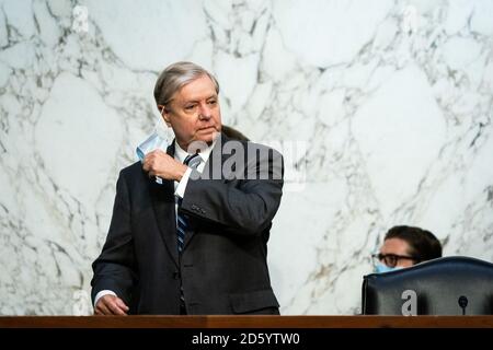 Senatorin der Vereinigten Staaten, Lindsey Graham (Republikaner von South Carolina), Vorsitzender des Justizausschusses des US-Senats, zieht seine Gesichtsmaske ab, bevor am 14. Oktober 2020 am dritten Tag der Bestätigungsverhandlung des Senats von Richterin Amy Coney Barrett vor dem Obersten Gerichtshof auf dem Capitol Hill in Washington, DC, begonnen wurde. Quelle: Erin Schaff/Pool über CNP /MediaPunch Stockfoto