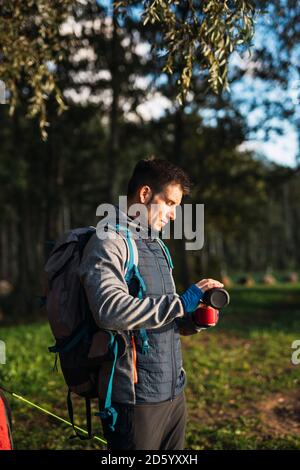 Mann camping in Estland, Wasser in eine Tasse gießen Stockfoto