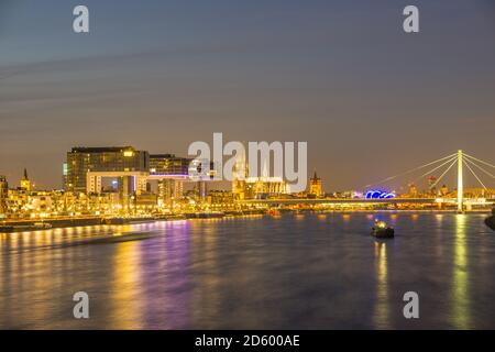 Deutschland, Nordrhein-Westfalen, Köln, Rheinau-Hafen mit Kran Häuser, Kölner Dom und Severins Brücke am Abend Stockfoto