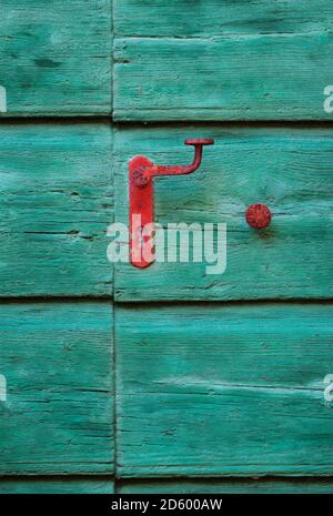 Holztür mit rotem Griff Stockfoto