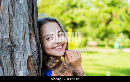 Immer lächelnd. Glückliches Mädchen lächeln am Baum auf der Sommerlandschaft. Zahngesundheit. Mundpflegeprodukte. Zahnpflege. Kinderzahnheilkunde. Mundhygiene beachten. Stockfoto