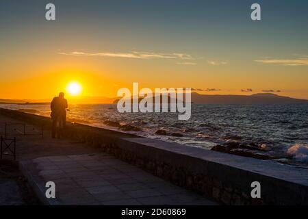 Griechenland, Kreta, Mann genießt den Sonnenuntergang in Chania Stockfoto