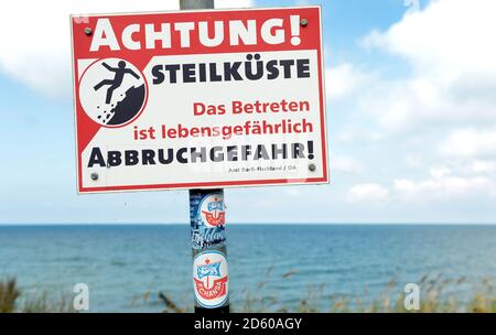 29. August 2020, Mecklenburg-Vorpommern, Darß: "Achtung! Steilküste, die darauf tritt, ist lebensbedrohliche Abbruchgefahr" steht auf einem Schild an der Ostsee am Darß. Foto: Volkmar Heinz/dpa-Zentralbild/ZB Stockfoto