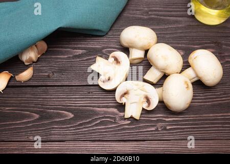 Geschnittene und ganze Pilze auf einem Holztisch. Der Blick von oben. Gesundes und leckeres vegetarisches Essen. Stockfoto
