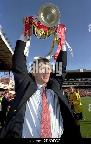 DATEI-FOTO: Arsene Wenger wird Arsenal am Ende der Saison verlassen und eine fast 22-jährige Regierungszeit beenden, als Manager Arsenal Manager Arsene Wenger feiert den Gewinn der Premiership mit der Trophy ... Fußball - FA Carling Premiership - Arsenal V Everton ... 03-05-1998 ... ... Keine ... Bildnachweis sollte lauten: Tony Marshall/EMPICS Sport. Eindeutige Referenz-Nr. 274813 ... Fußball - Premiership - Arsenal gegen Everton Arsenal-Manager Arsene Wenger feiert die siegreiche Premiership Trophy Stockfoto