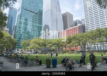 Blick quer über den Bryant Park mit Bürogebäuden, die im Hintergrund entlang der 42nd Street und 6th Avenue in Midtown Manhattan, New York City, aufragen. Stockfoto