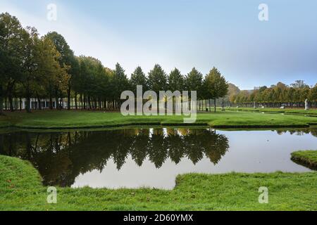 Baumreihen im Schweriner Schlosspark spiegeln sich im Wasser, Kopierraum am blauen Himmel, ausgewählter Fokus Stockfoto