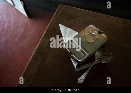 Bolpur, Westbengalen/Indien - 10.10.2020: Lebendige Metall-Lunchbox mit Stahllöffeln - Draufsicht, Nahaufnahme. Papierserviette und Haushaltsutensilien. Stockfoto