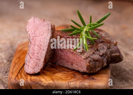 Gegrilltes Steak auf Holz mit Rosmarin Stockfoto