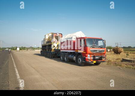 Ein Volvo Abziehwagen zieht einen Diesel Lokomotive irgendwo in Indien. Stockfoto