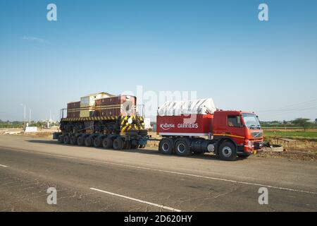 Ein Volvo Abziehwagen zieht einen Diesel Lokomotive irgendwo in Indien. Stockfoto