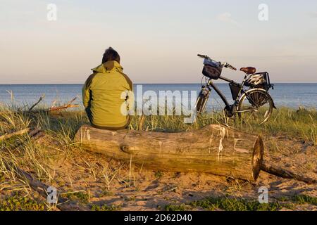 Fahrradwanderer, der auf einem Küstenwanderweg neben der Küste sitzt Stockfoto