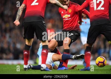 Sergio Aguero von Manchester City scheint in der gefangen zu werden Face Kauf das Knie von Manchester United Marouane Fellaini Stockfoto