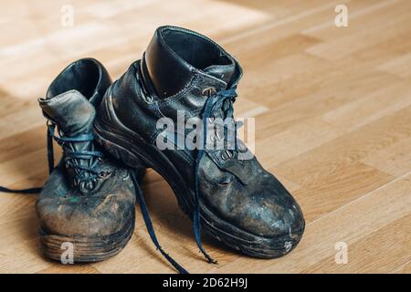 Alte abgenutzte Arbeitsschuhe. Schuhe, die repariert oder ersetzt werden müssen Stockfoto