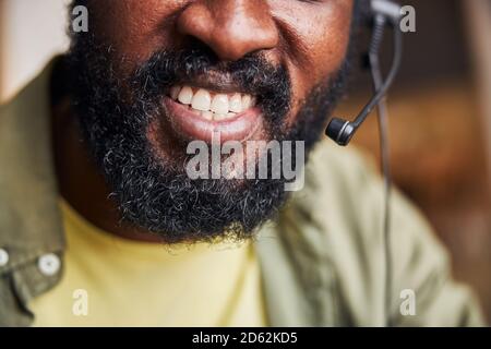 Afroamerikanischer junger Mann mit Kopfhörern, der positive Emotionen ausdrückt Stockfoto