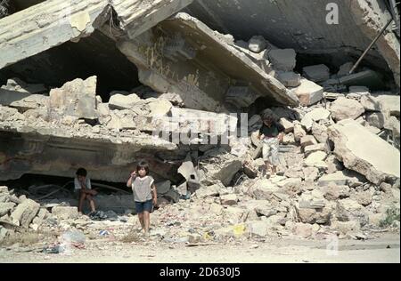18. September 1993 Kinder spielen im Schutz eines riesigen Schutthaufens auf dem Märtyrerplatz in Beirut. Stockfoto