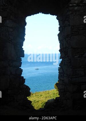 Okt 2020 - Boot gerahmt im Fenster von Dunskey Castle in der Nähe von Portpatrick Schottland. Das Boot fährt über den Ort der geplanten Straßenverbindung von Schottland nach Irland - Portpatrick ist die geplante Endstation für eine geplante Tunnel- oder Brückenverbindung nach Larne in Irland. Stockfoto