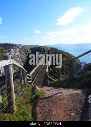 Okt 2020 -Brücke über eine Schlucht auf dem Fußweg zum Dunskey Castle in der Nähe von Portpatrick Schottland. Portpatrick ist die geplante Endstation für einen geplanten Tunnel oder eine Brücke, die mit Larne in Irland verbunden ist. Stockfoto
