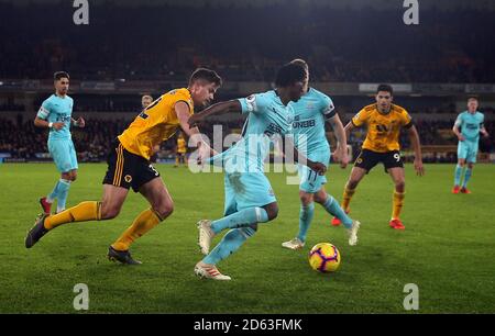 Christian Atsu (Mitte) von Newcastle United unter dem Druck von Wolverhampton Wanderers' Leander Dendoncker (links) Stockfoto